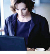 Image of a Businesswoman in blue suit working on her computer in a non-office environment